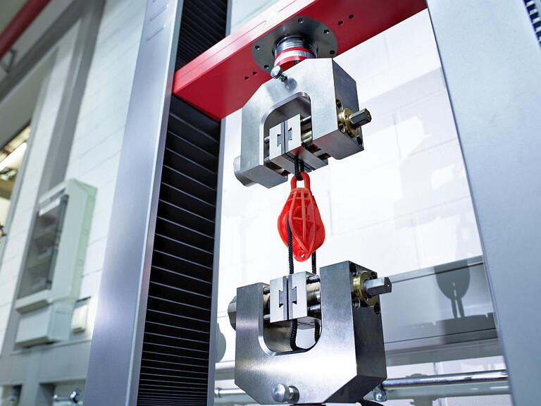 Komplette Bauteilgruppe: Eine über Gelenke bewegliche Seilrolle samt Gehäuse und Befestigungshaken, mit dem Freeformer additiv aus Bio-Polyamid gefertigt. (Foto: Arburg)