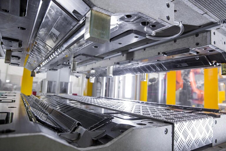 Das Nasspressverfahren wird zur Herstellung von Carbonfaserbauteilen mit geringer dreidimensionaler Komplexität wie Fahrzeug-Antriebstunnel oder Verstärkungen im Dachbereich eingesetzt. (Foto: Dieffenbacher)