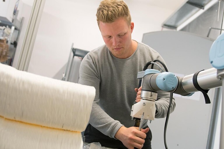 Moritz Wesseler stattet den Roboterarm mit einem Extruder aus. (Foto: FH Münster)