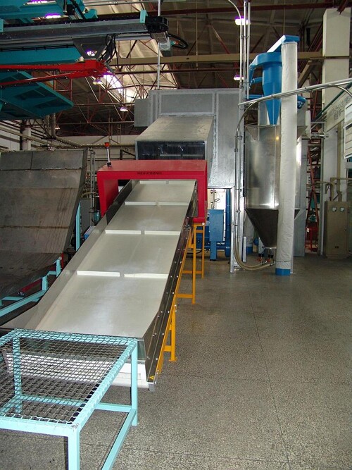 Großmühle der Baureihe RS 6000 in einer Schalldämmkabine für die Zerkleinerung blasgeformter Kraftstofftanks. Das zuführende Förderband dient der zusätzlichen Abkühlung der Tanks. (Foto: Getecha)