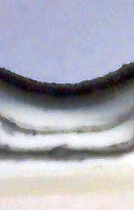 Mikroskopaufnahme eines Querschnitts durch den Bindenahtbereich eines Formteils, der zeigt, dass die Schmelze in der neuartigen Mischzone des Blaskopfes in mehrere Schichten aufgeteilt wird, die dann schließlich in der Bauteilwand wie bei einem coextrudierten Teil übereinanderliegen (Foto: Groß Kunststoff-Verfahrenstechnik)
