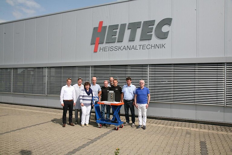 Das Team der ersten Stunde – in der Mitte das 2-Kavitäten-Werkzeug für das Siphon-Unterteil. Rechts im Bild Geschäftsführer Hans Schreck. (Foto: Heitec)