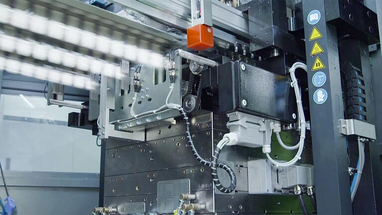 Ein dreireihiges Lineargreifersystem übergibt die Vorformlinge an die Streck-Blas-Einheit. (Foto: Kiefel)