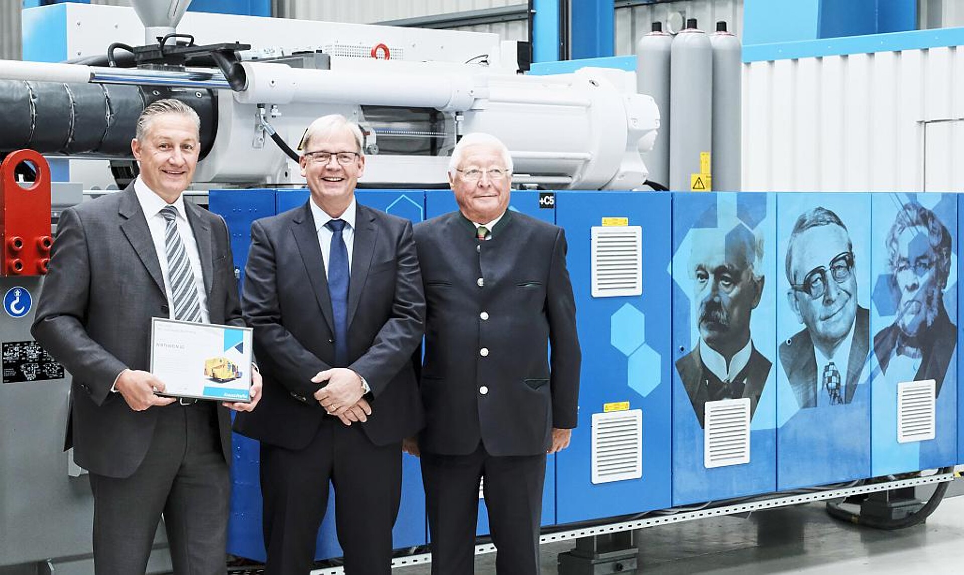 Tradition und Moderne vereint: Marcus Wirthwein, Dr. Hans Ulrich Golz und Udo Wirthwein vor der Jubiläumsmaschine. (Foto: KraussMaffei)