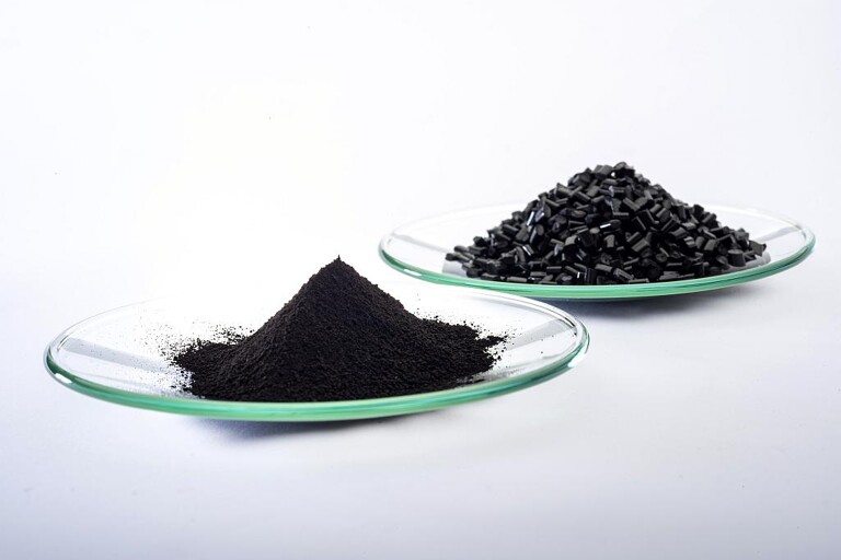 Das Schwarzpigment Bayferrox 303 T (vorn) wird zur Einfärbung von Masterbatches (hinten) verwendet. Es kann die Lebensdauer von Kunststoffbauteilen aufgrund einer deutlich reduzierten Wärme-Adsorption verlängern. (Foto: Lanxess)