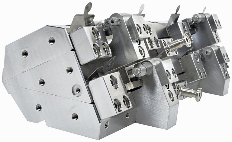 In dieser Rückansicht eines Zweischichtmodells einer Premier-Fluidbeschichtungsdüse sind die Ausgleichsblöcke entlang der Düsenbreite angeordnet. Die Ausgleichsbleche ragen aus ihnen hervor. An der Seite der Düse sind zwei Fließkanäle zu sehen, die auf die Düsenlippen gerichtet sind. (Foto: Nordson)