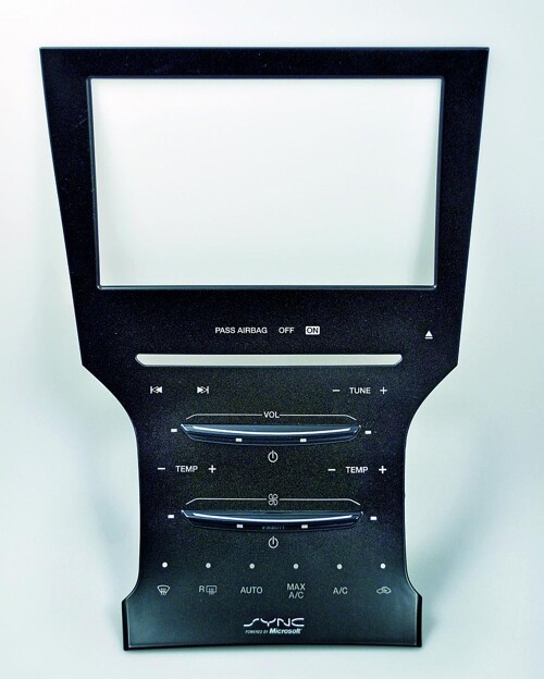 Für das Lincoln MKZ Center Stack wird die hochtransparente PC-Hard-Coat-Folie vorderseitig partiell mit mattierten Dual-Cure-Lack überdruckt, das Dekor wird auf die Folienrückseite gedruckt. Die Folien werden 3D-geformt und die Oberfläche wird mit UV-Licht gehärtet und gestanzt. Anschließend werden die Folien direkt mit PC/ABS hinterspritzt. (Foto: Lincoln MKZ Center Stack)