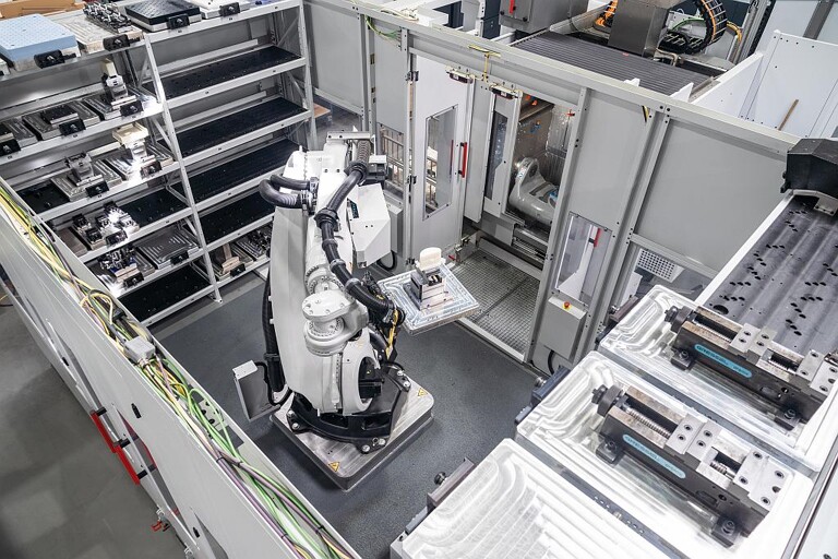 Der Roboter RS 2 entnimmt eine Palette mit einem fertig bearbeiteten Kunststoffteil aus dem 5-Achs-Bearbeitungszentrum. (Foto: Hermle)