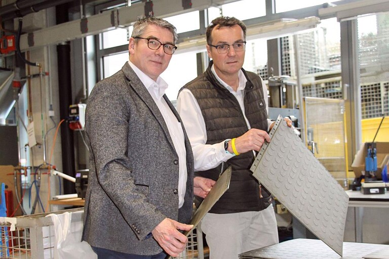 Dirk Wevelsiep zeigt Thomas Bertram die neue Produktentwicklung, eine Bodenplatte mit selbstabdichtendem Hinterschnitt. (Foto: Wittmann Battenfeld)