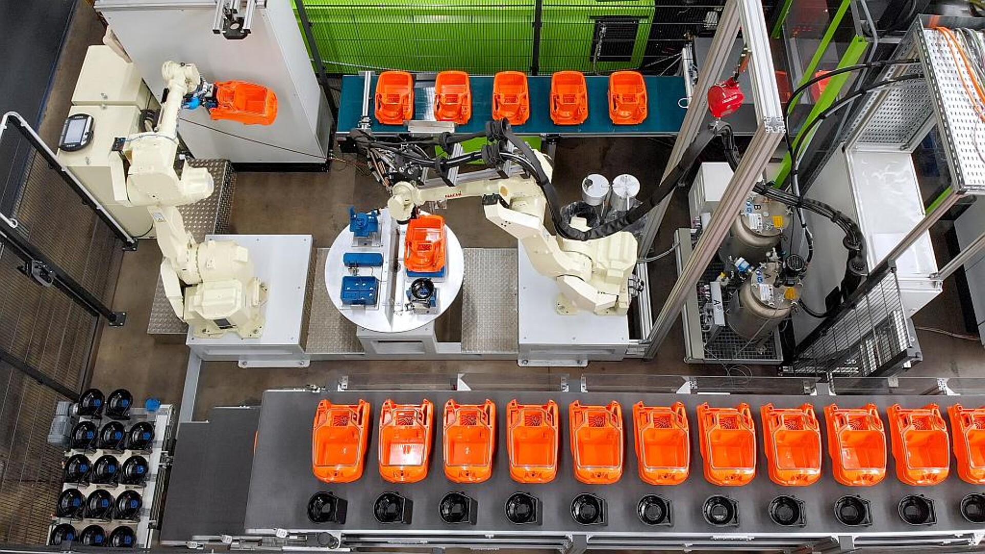 Der 6-Achsroboter legt das Staubsauger- und Motortopfgehäuse für den Dosierauftrag in einem Schritt auf den Rundtakttisch-Teileaufnahmen ab. (Foto: Henkel)