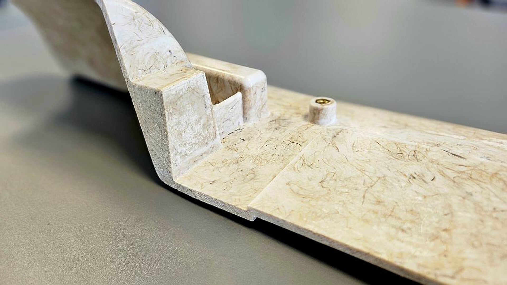 Detailaufnahme eines Bauteils aus Naturfaser-SMCs (Zuginnenverkleidung). Gut sichtbar sind neben dem Faserverlauf die geometrischen Freiheitsgrade, die das Material erlaubt. (Foto: Fraunhofer IWU)