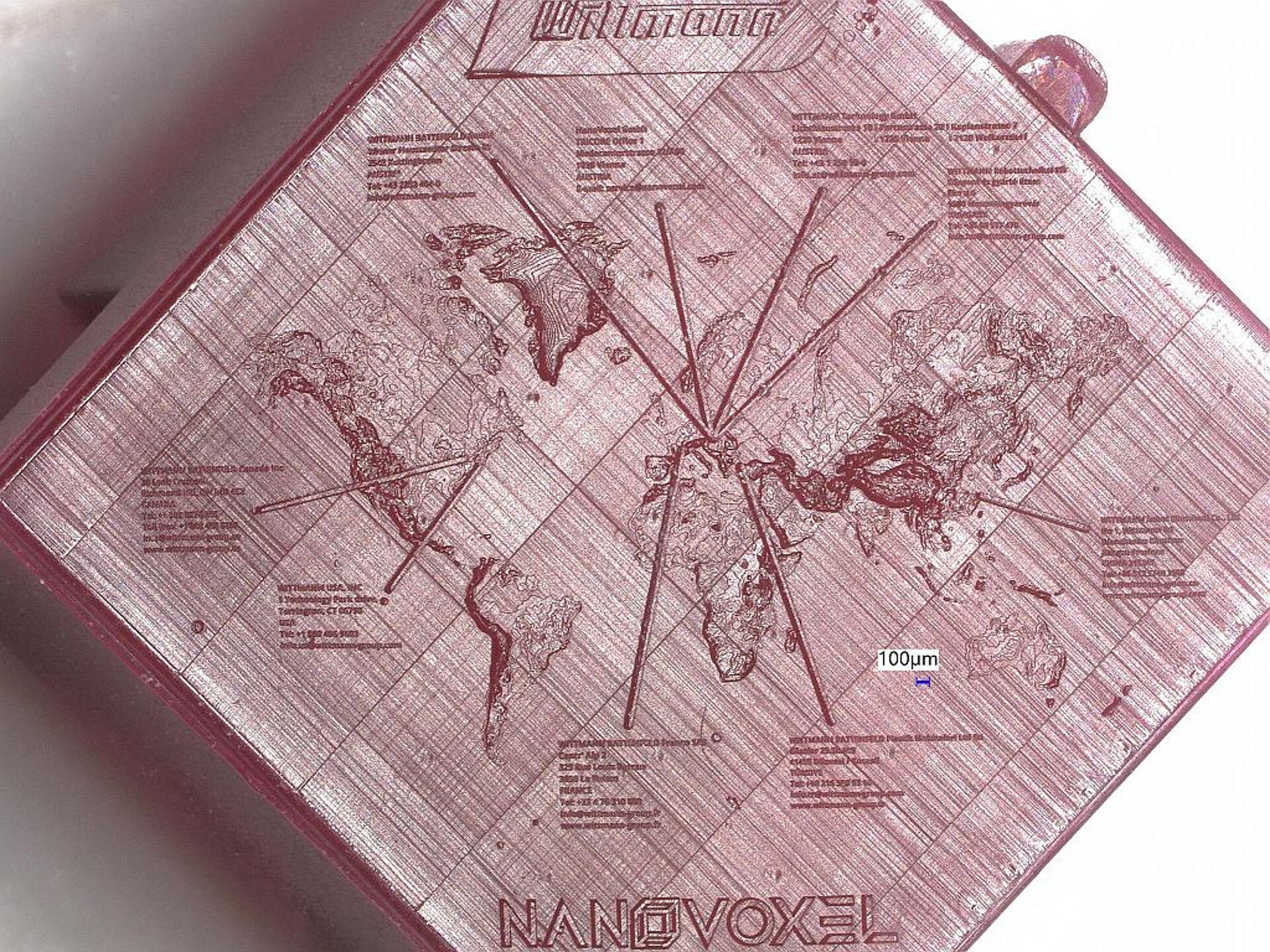 Auf einem 8,5 x 8,5 mm kleinen Demoplättchen bilden Nanostrukturen die Weltkarte mit Wittmann-Produktionsstandorten ab. (Foto: NanoVoxel)