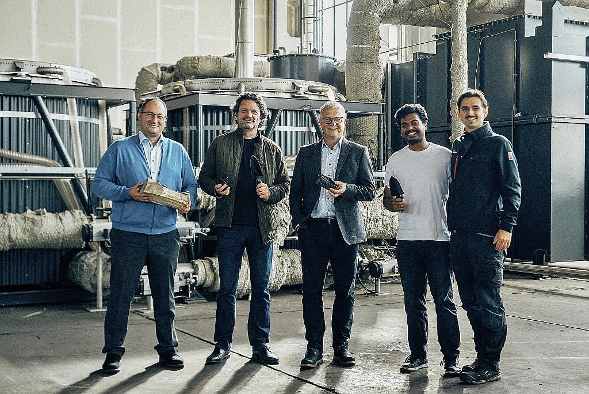 Manuel Witte (l.), Abteilungsleiter Anwendungstechnik & Branchen bei Arburg, und Gerhard Böhm (M.), Arburg-Geschäftsführer zur Zeit der Vertragsunterzeichnung mit Christoph Hiemer (2. v. l.), Mitgründer carbonauten, und Team in der „minus CO2 factory 001“ in Eberswalde bei Berlin. (Foto: carbonauten)
