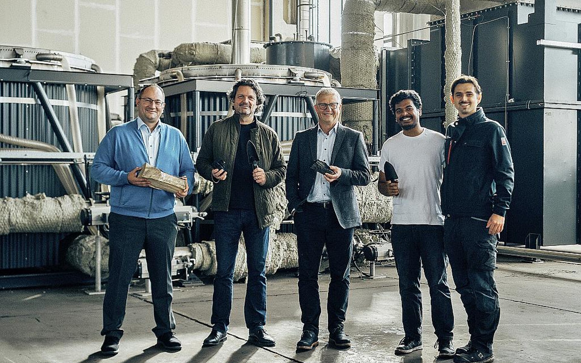 Manuel Witte (l.), Abteilungsleiter Anwendungstechnik & Branchen bei Arburg, und Gerhard Böhm (M.), Arburg-Geschäftsführer zur Zeit der Vertragsunterzeichnung mit Christoph Hiemer (2. v. l.), Mitgründer carbonauten, und Team in der „minus CO2 factory 001“ in Eberswalde bei Berlin. (Foto: carbonauten)