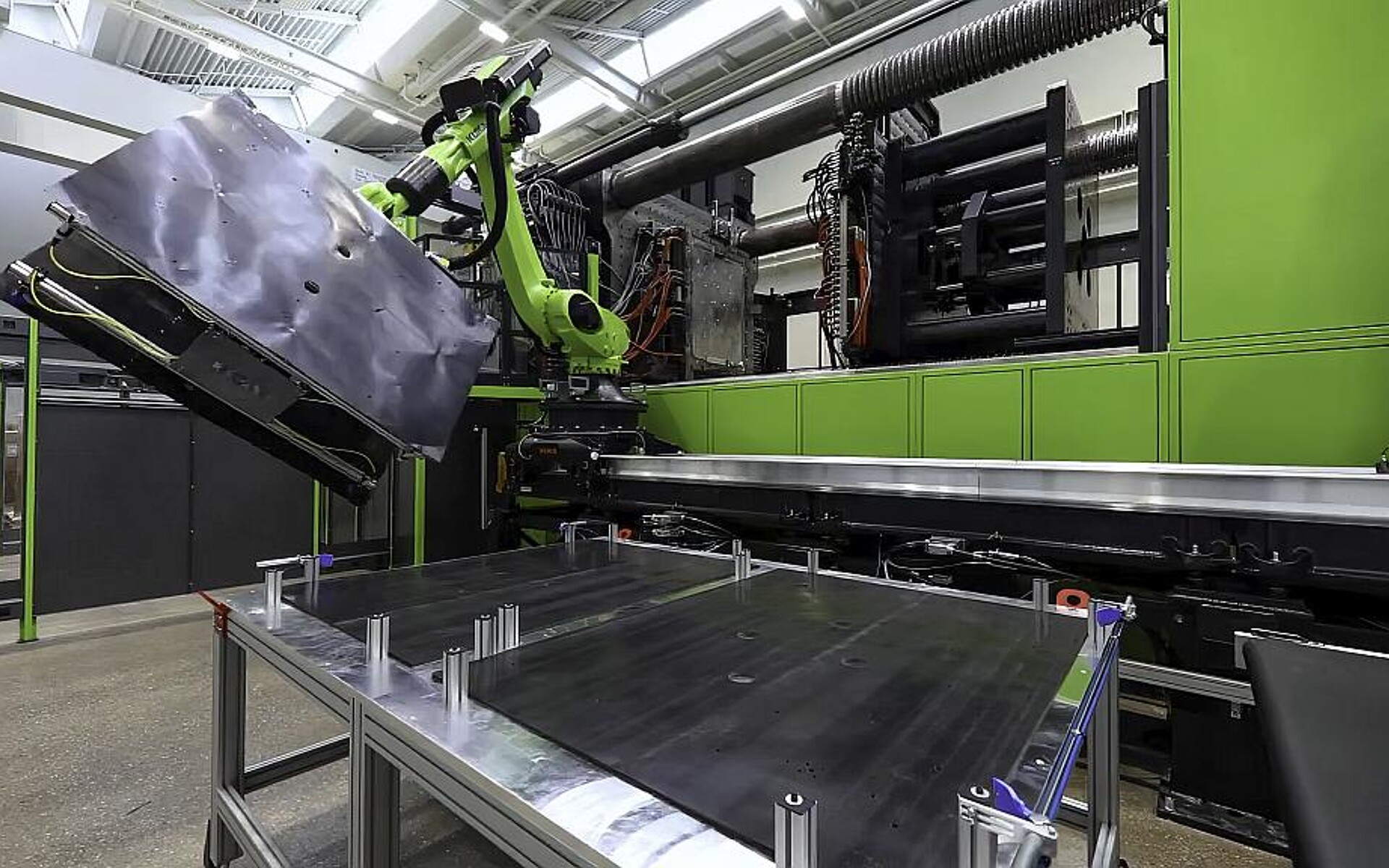 Produktion eines großformatigen Batteriedeckels aus dem Bereich Elektromobilität auf der weltweit größten Spritzgießmaschine in einem Technikum. (Foto: Engel)