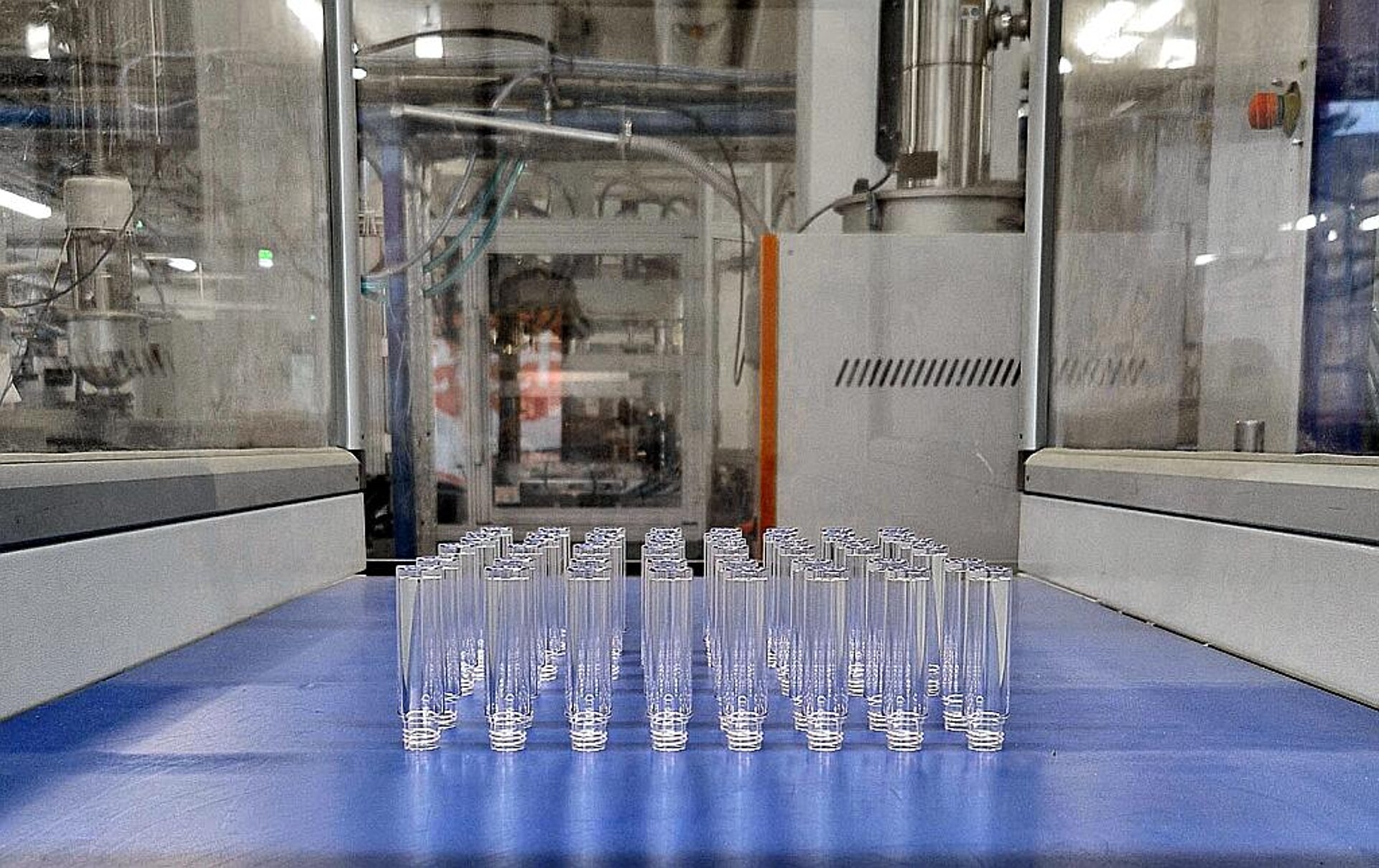 Kleine zylindrische PET-Flaschen laufen vom Austaktband einer Spritzgießmaschine EcoPower 300. (Foto: Bell)
