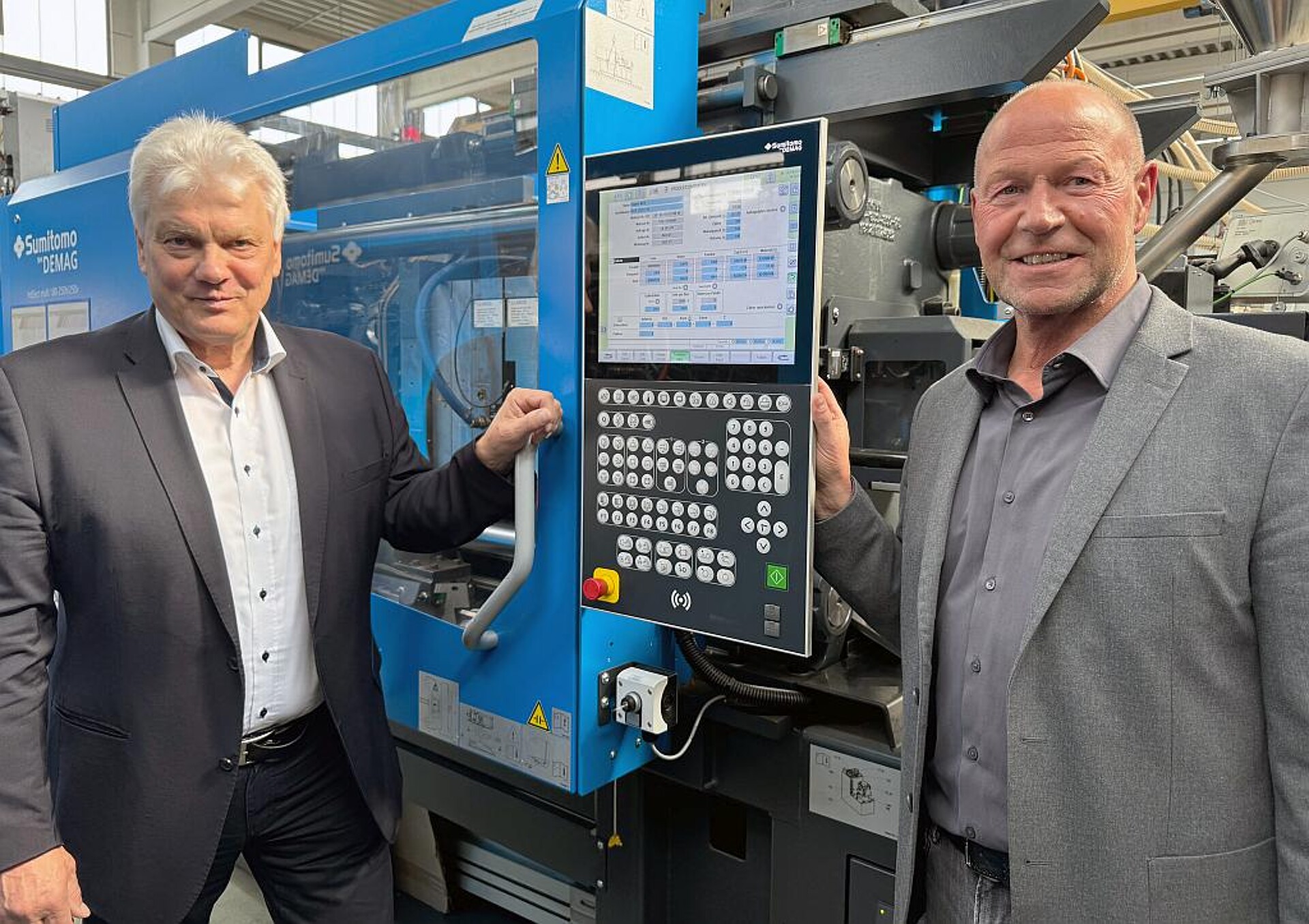 Dr. Gerald Fiedler (l.), Vertriebsingenieur bei Sumitomo (SHI) Demag, und Ralf Schiefer, Head of Strategic Business + Product Development bei HSK, an einer neuen 2K-Maschine IntElect Multi 180 im Werk in Crottendorf. (Foto: Sumitomo (SHI) Demag)