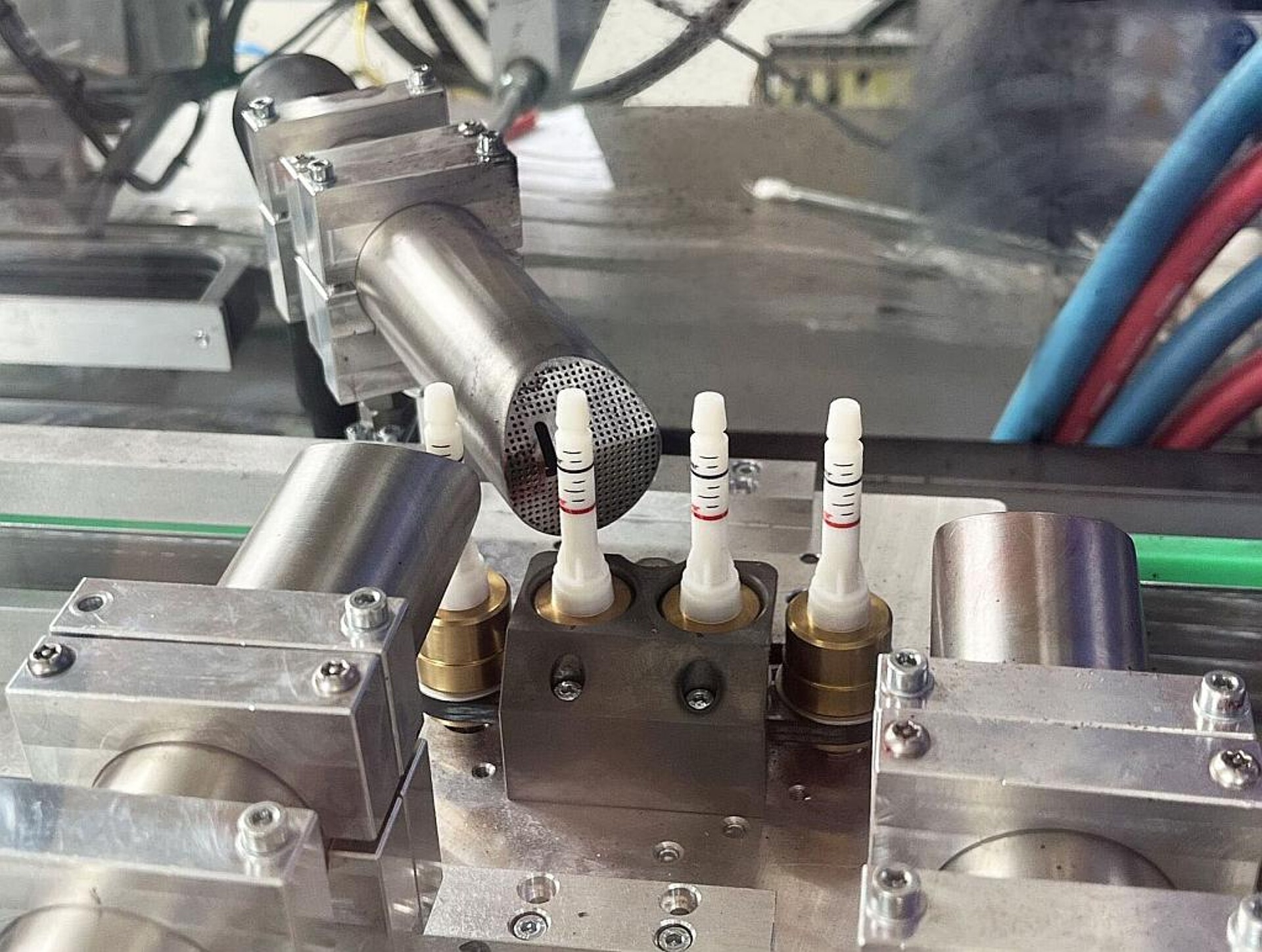Die drei Tintenstrahldruckerdüsen versehen die Kolben jeweils mit einem roten und einem schwarzen Ring sowie einer Skala. Um die Ringe effizient zu drucken, rotieren die Kolbenhalter auf dem Transportschlitten. (Foto: Mesto)